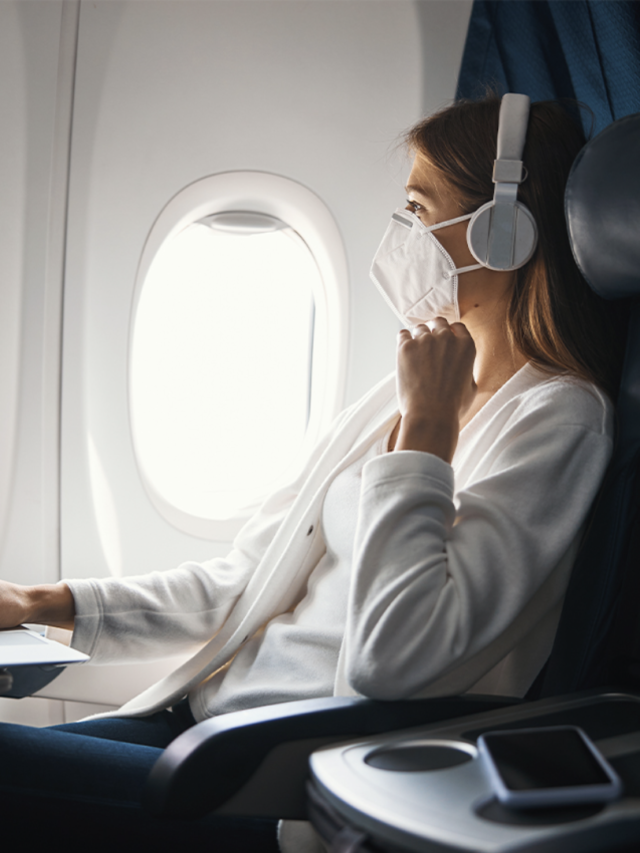 IMAGE: A young women wearing a mask on a plane